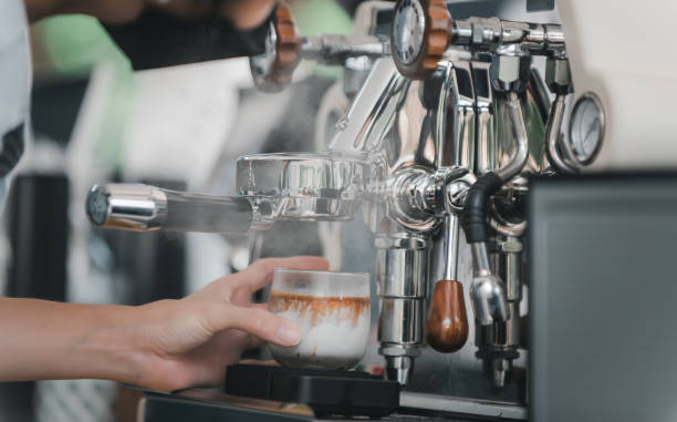 istock Young woman barista using coffee machine for making coffee in the cafe 1405336096