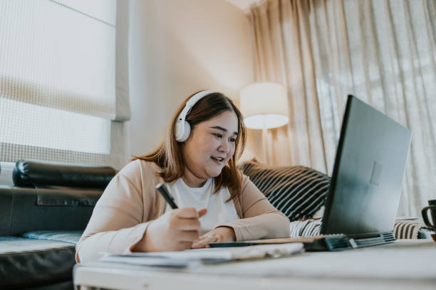 Enjoy master's degree online class at home. Asian woman studying her first master's degree class, enjoy and happy to see her classmates. mba online stock pictures, royalty-free photos & images