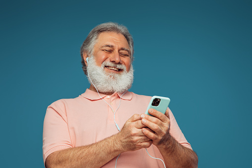 Portrait of emotional old man using smart phone