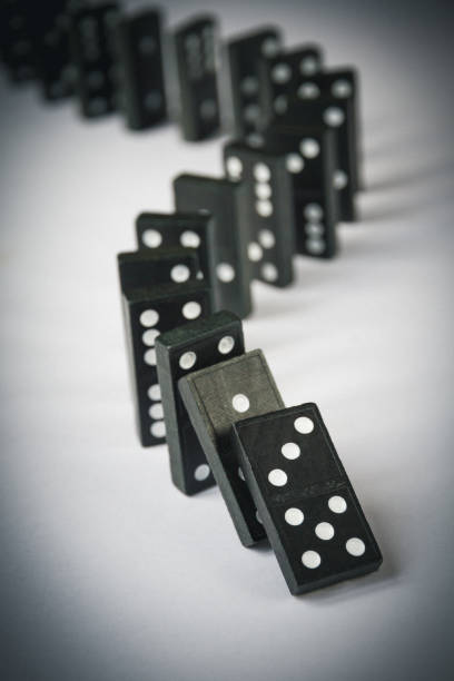 istock Black dominoes chain on white table background 1405346080