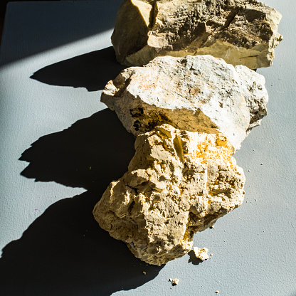 Three different types of rocks in sunlight, forming shadows. Kaolinite, Montmorillonite, clay minerals