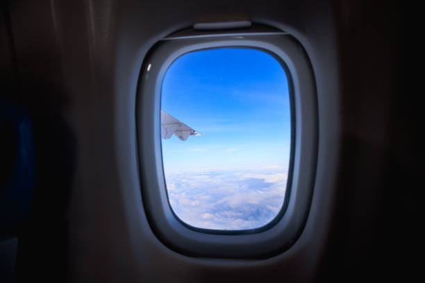 View on white clouds and sky above through the airplane window