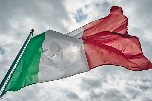 The sun shining through the Italian flag on a windy day.