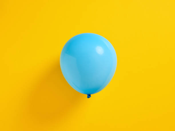 istock Blue inflated balloon on yellow background. 1405355747