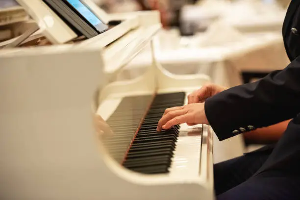 Close-up of unrecognizable man playing the piano