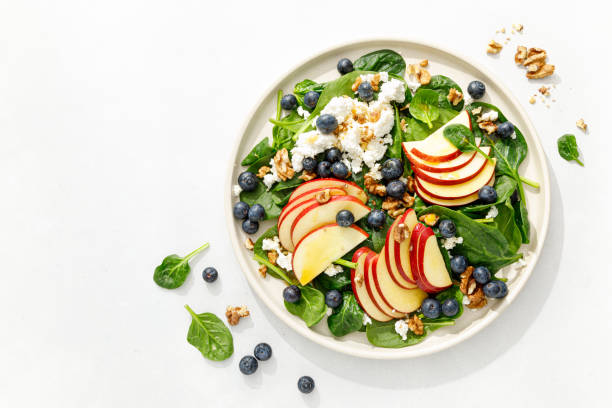 apple and spinach fresh sweet fruit salad with blueberry, cheese cottage and walnuts, top view - plate food color image photography imagens e fotografias de stock