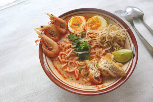 istock laksa, laksa curry made from vermicelli, noodles, bean sprouts, egg, tofu lime, and shrimp with a spicy soup sauce that is rich in spices. laksa served on bowl, isolated on white background. 1405357988