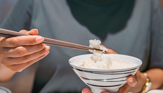 Asian woman eating rice at Japanese restaurant