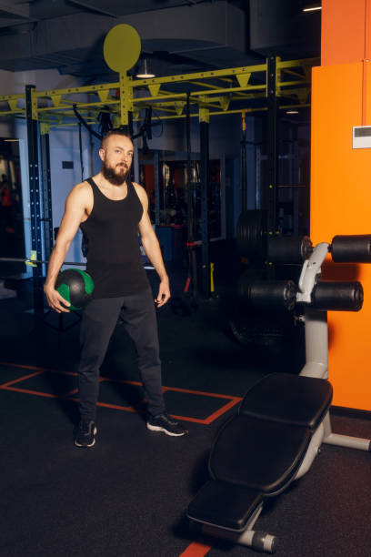 istock A young man with a beard is posing in the gym with ball 1405361903