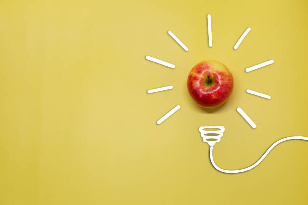 istock Creative thinking ideas and innovation concept. A ball of apple with a light bulb symbol on a yellow background. Time for a healthy diet 1405362404