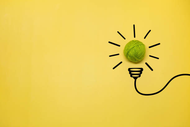 istock Creative thinking ideas and innovation concept. A ball of green threads with a light bulb symbol on a yellow background 1405362408