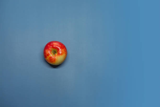 istock A red apple lies on a purple background. 1405362481