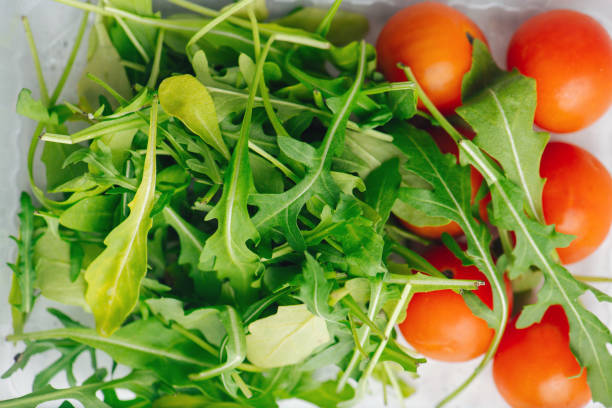 ルコーラの葉とチェリートマトのクローズアップトップビュー - healthy eating red above studio shot ストックフォトと画像