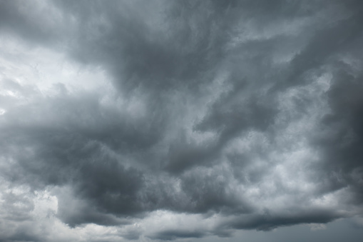 A dramatic dark storm cloudy sky or cloudscape.  Wide-angle view, gray clouds, no people.
