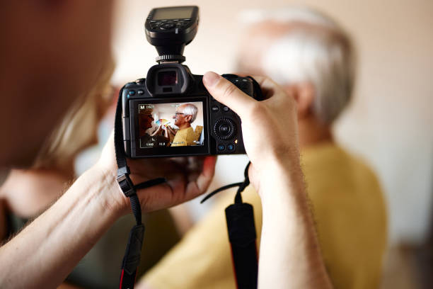 Close up of a photographer taking a phot of senior couple choosing colors during home renovation process.
