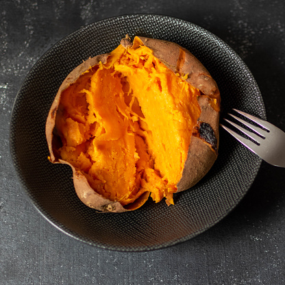 Sweet potato baked in oven on a black background