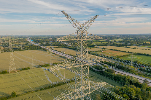 Power line, power supply with countryside landscape. Electricity grid expansion for the energy transition. Electricity pylons.