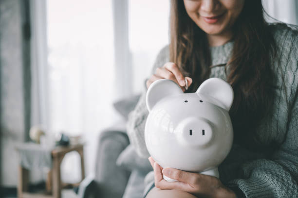 Happy smart Asian female hand putting money coin into piggy for saving money wealth and financial concept. feliz mano femenina asiática inteligente poniendo moneda de dinero en piggy para sahappy mano femenina asiática inteligente poniendo moneda de dinero en piggy para ahorrar dinero riqueza y concepto financiero.ving riqueza monetaria y concepto financiero.