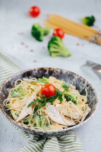 istock Pasta with chicken breast meat and broccoli. Single cherry tomato in the middle 1405370420