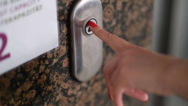istock Female finger with red manicure pressing elevator button closeup 1405370494