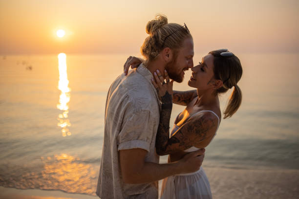 istock Married couple kissing on the beach during sunset 1405375650