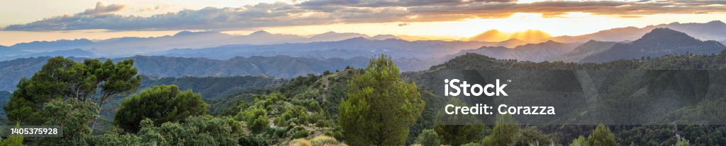 Incredible landscape of the mountains of Malaga with sunset in the cloudy sky. Beautiful mountain scenery with a vivid sunset in the cloudy sky, feeling of peace, serenity and freshness. Mountains of Malaga. Nature Stock Photo
