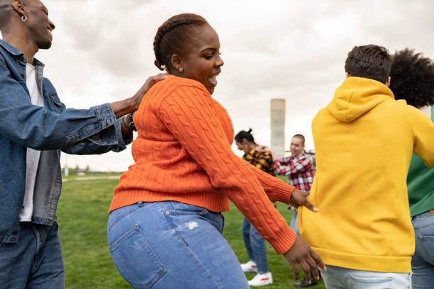 group of funny friends dancing outside, focus on curvy woman group of funny friends dancing outside, focus on curvy woman huge black woman pictures stock pictures, royalty-free photos & images