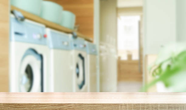 istock Laundry room table background. Blurred home laundry room with wooden table display for product. 1405377383