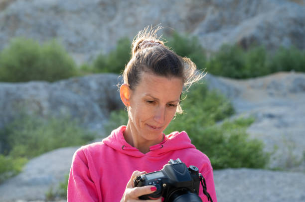 istock Young female photographer checking her camera settings 1405379043