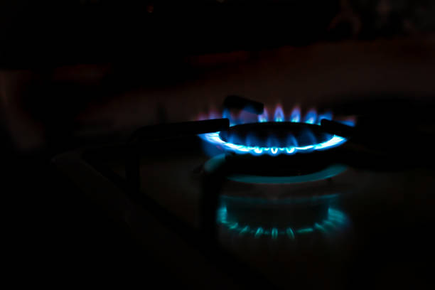 istock Gas stove burner with blue flame with reflection in the dark, copy space, blurred background. gas crisis 1405379775