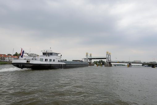 Freight ship carrying bulk goods over the river IJssel near Kampen during a  summer day in the IJsseldelta region in Overijssel, The Netherlands.