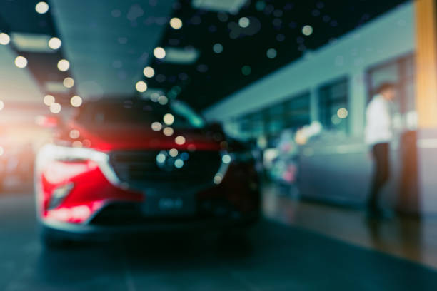 Blurred photo new red car parked in showroom. Car dealership office. Car parked in showroom with care. Auto for sale and rent business. Automobile leasing market. Electric vehicle. Luxury car company. stock photo