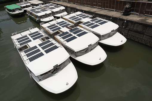 Solar power panel Cells are mounted on the roof of a white tourist boats.