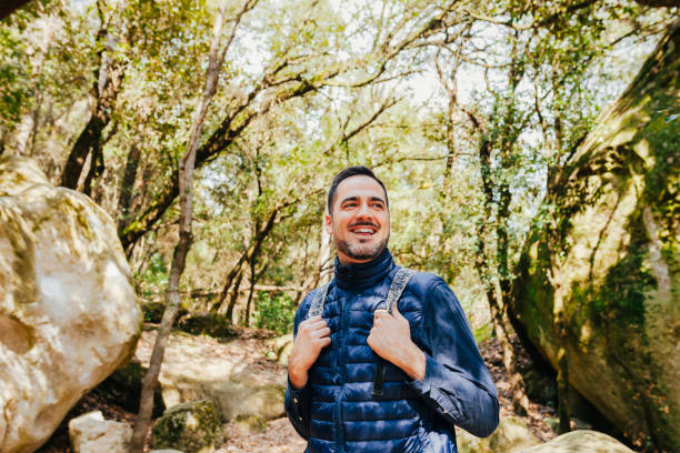 istock Young happy smiling hiker man hiking in forest with backpack 1405381942