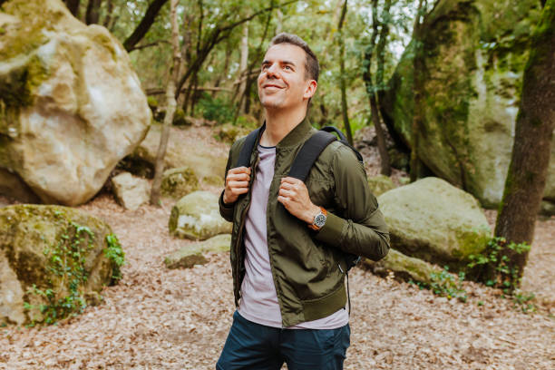 istock Young cheerful hiker man hiking in forest with backpack 1405381946