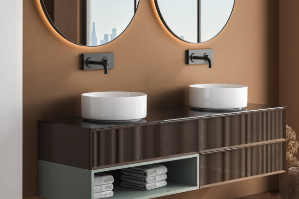 istock Close up modern countertop design with  white double ceramic sinks and a stylish round mirrors 1405382889