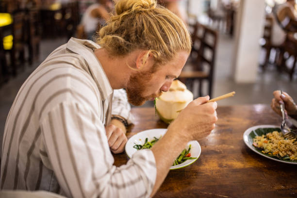 istock Caucasian man eating Thai food with chopsticks 1405382937