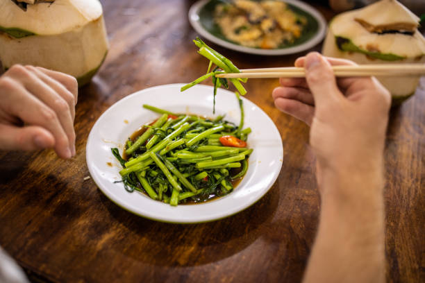 Unrecognizable man eating Thai food with chopsticks