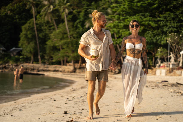 istock Carefree young couple walking on the beach while holding hands 1405383777
