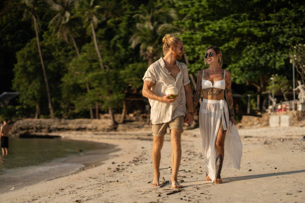 istock Young Caucasian couple walking on the beach 1405384431