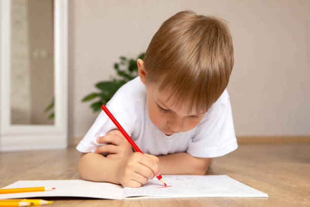 istock A little boy draws lying on the floor. 1405384566