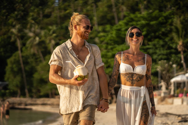 istock Young Caucasian couple walking on the beach 1405384692