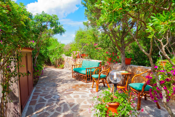 Outdoor green garden beach patio wooden bench in backyard porch of home with nobody in Sardinia tropical house stock photo