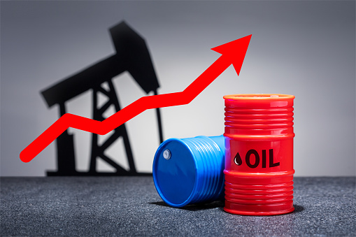 Oil barrels with a red up arrow on grey background. Oil chart.