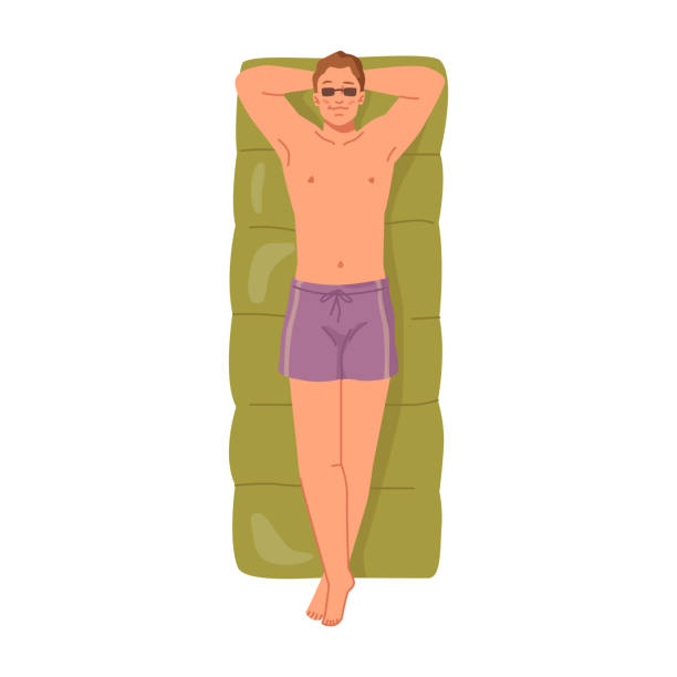 illustrazioni stock, clip art, cartoni animati e icone di tendenza di bello uomo estate relax abbronzatura prendere il sole su asciugamano o tappetino da bagno gonfiabile prendere il sole al sole. vista dall'alto del giovane in pantaloncini e occhiali che si rilassano in spiaggia - shorts swimming shorts swimwear men