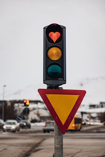 Traffic Light Detail with a Heart Shaped Red Light from below against twilight sky. Heart Shaped Love Symbol in Red Stop Light inside a typical City Traffic Light in the City of Akureyri, Northern Iceland. Akureyri, Iceland, Northern Europe.