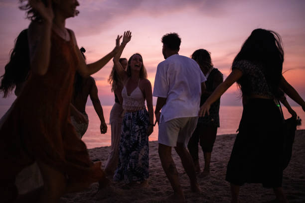 istock Group of multiracial people dancing on the beach during sunset 1405388211