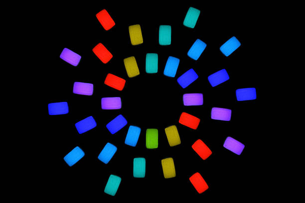 Neon glow sun shape made from three rows of jelly cubes isolated on black background. Bright party background.