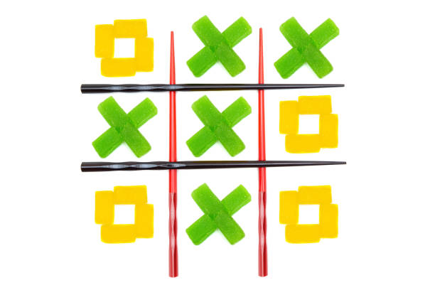 Tic-tac-toe grid made from chopsticks and jelly candies isolated on white background.