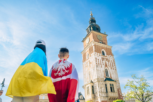 woman and little boy covered with ukraine and poland flag in Krakow city center friendship shelter